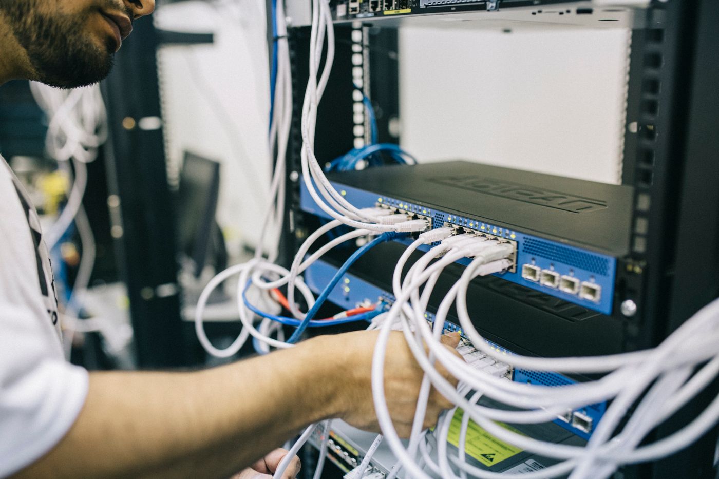 Technician working on network switches and server rack equipment